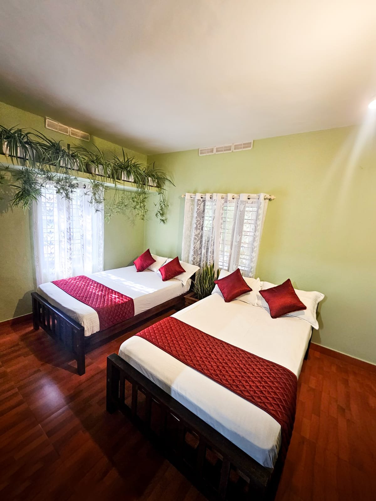 Room with two double beds and red cushions